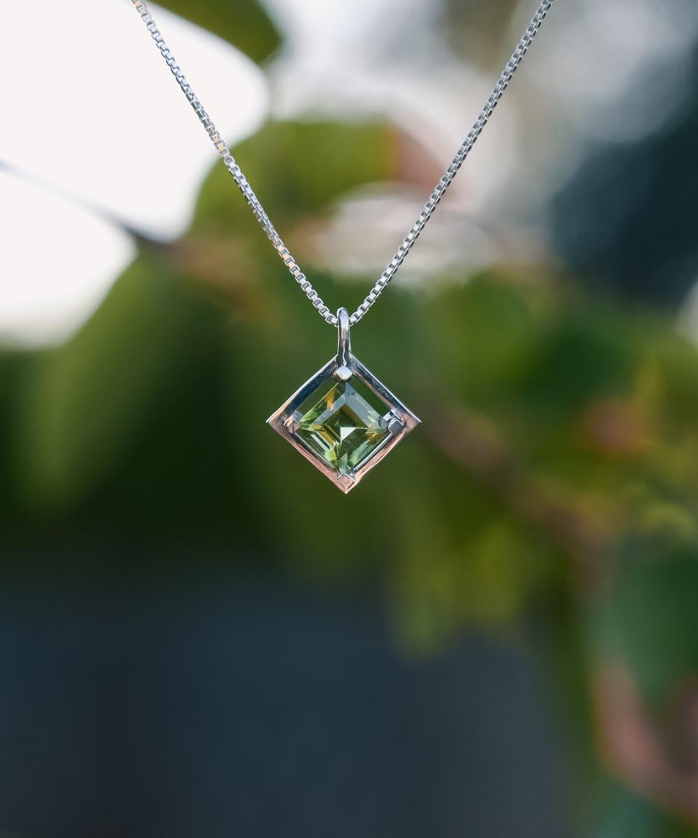 Silver necklace with a princess cut arizona peridot. Button in top left of image reads FIGURAE and will take you to all geometric themed items